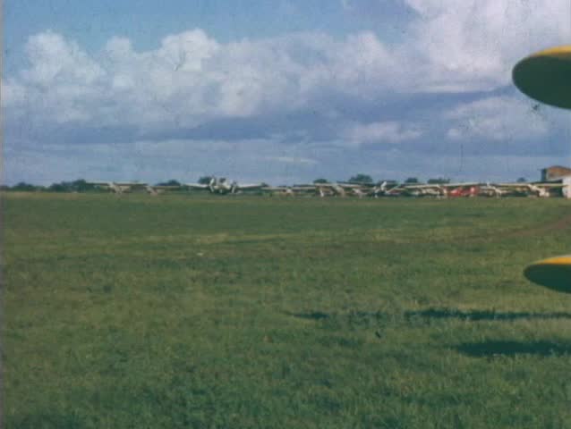 hand-held pan of an airfield in  1960 biplanes and fixed wing aircraft cessna