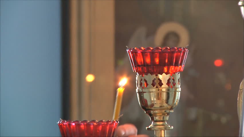 the priest lights a candle.