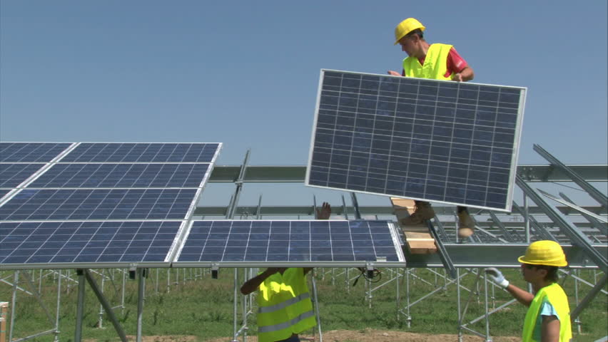 Workers are mounting panels on solar power-plant construction.