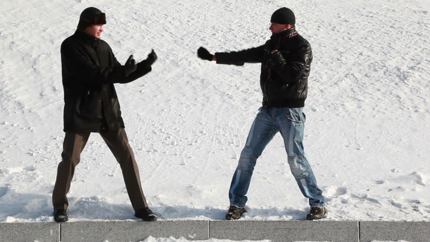 two young men snowy winter playfully imitating boxing match in ancient style of advancing and retreating