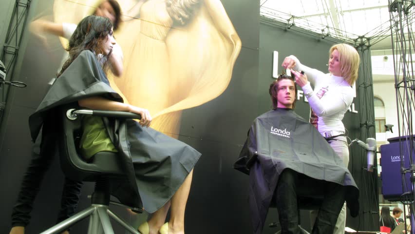 MOSCOW - SEPTEMBER 30: Hair stylist works at Londa stand on XVII festival Mir Krasoty, September 30, 2010 in Moscow, Russia. Over 70 well-known cosmetics firms presented their goods and services at the trade fare.