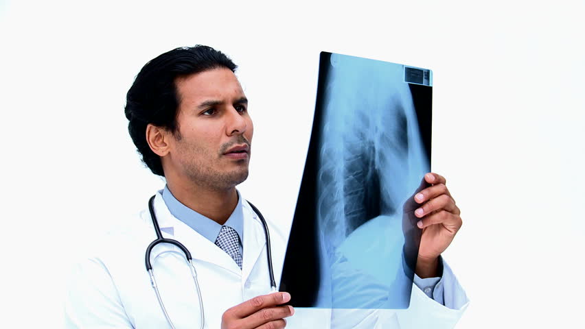 Surgeon looking at an x ray  against a white background