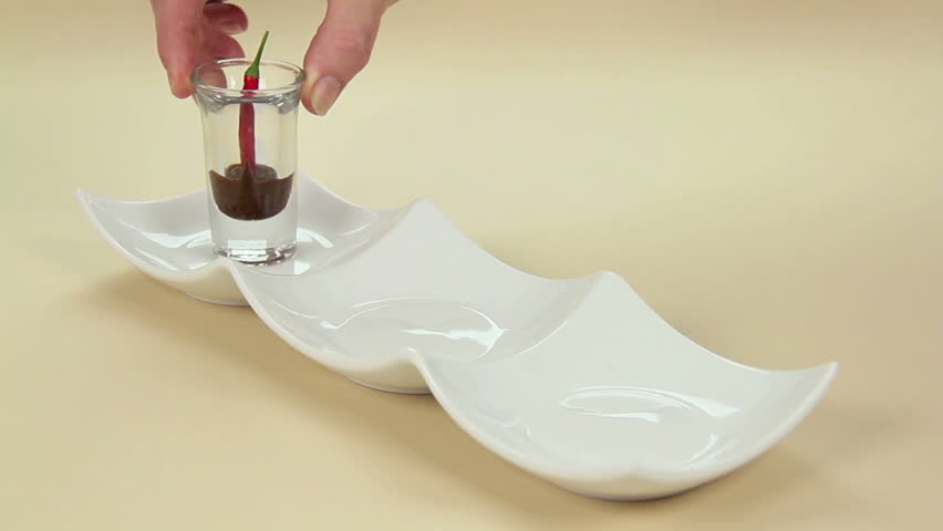 Three quarter shot of putting glasses with chillies and chocolate on a tray for dessert.