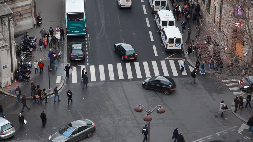 busy traffic at intersection and crosswalk in center of Paris by day, top view