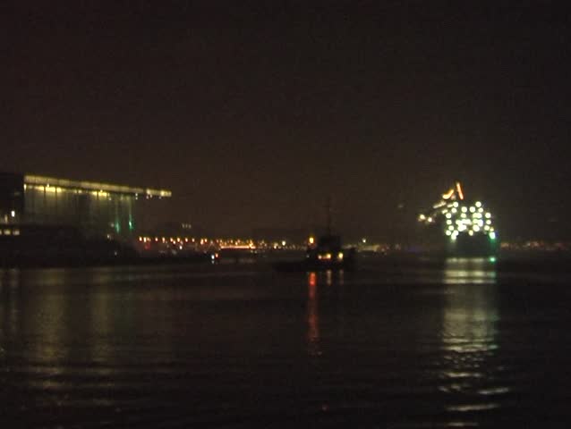 Cruiseship by night moving in Amsterdam harbor in the Netherlands