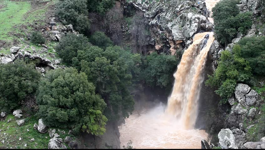 Banias Falls in the winter at the Golan Heights (Israel). Orange color of water because of washout of the earth from fields as a result of heavy rains. 
