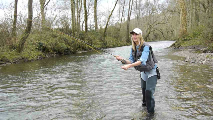 Woman fly-fishing in river