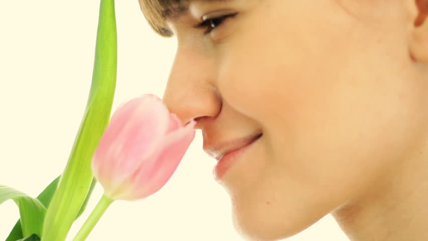 Young attractive woman smelling spring tulip, isolated