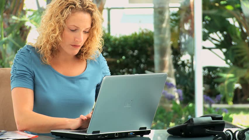 Curly haired lady working on a laptop at a desk