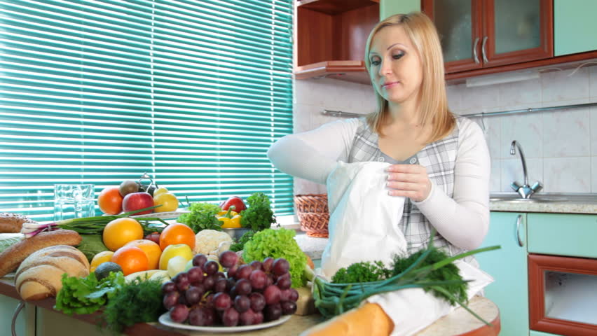 Pregnant woman with Groceries in kitchen