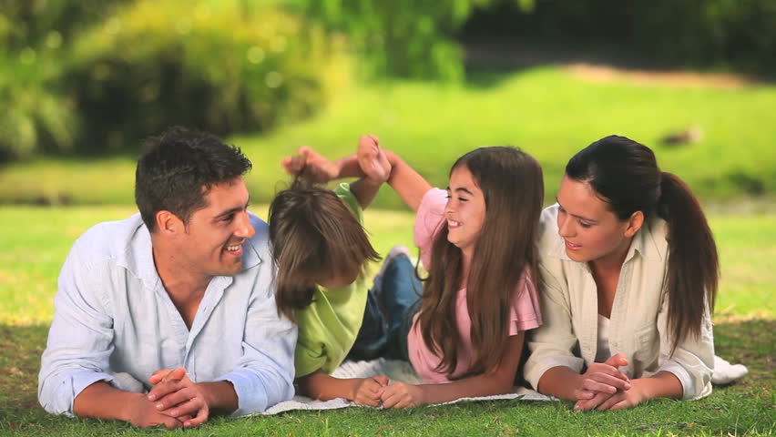 Parents lying down with their children in the park