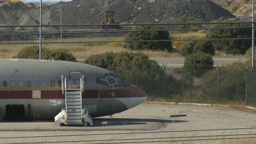 This is a medium shot of 1 airplane sitting in the California sun rusting. Looks like it was dismantled decades ago. Here, you can see the nose of the aircraft an a set of stairs leading to the hatch.