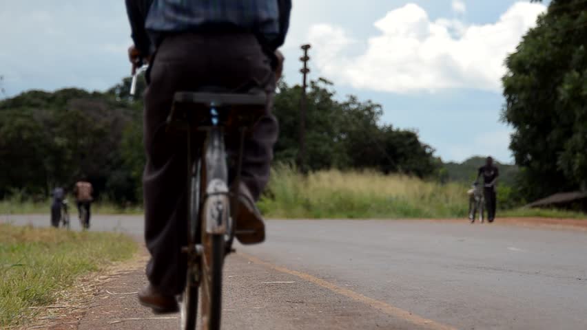 SALIMA, MALAWI - CIRCA APRIL 2011: African cyclists on a main road circa April 2011 in Salima, Malawi. Malawi is among the world's least developed countries; Only about 45 percent of its roads are paved.  