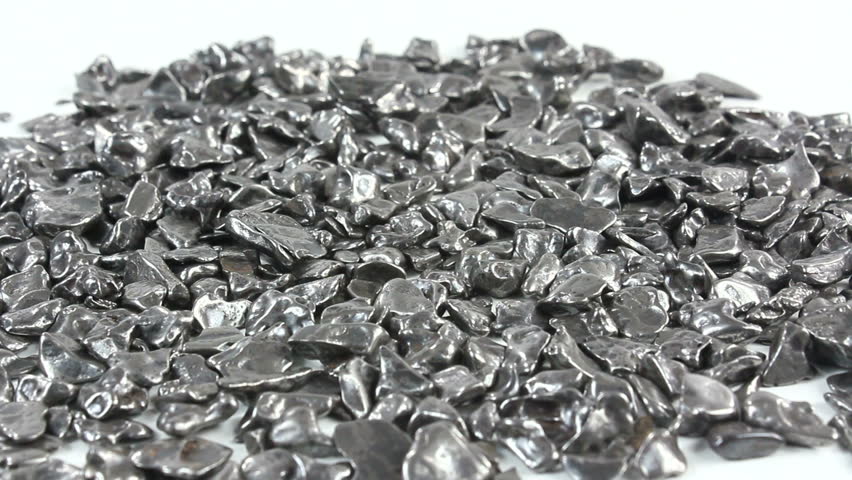 Magnet attracts polished, iron meteorite fragments, pieces of space rock that survived the fiery descent through earth's atmosphere and landed on earth, displaying space rock's magnetic properties.