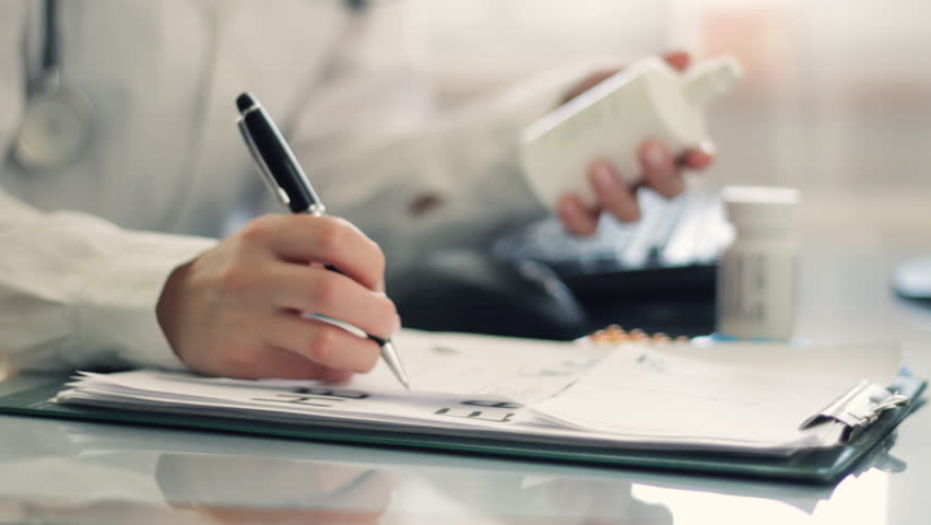 Female doctor hands writing rx prescription
