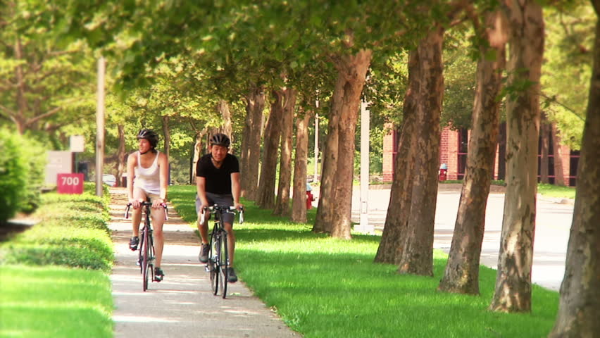 A young couple bike and sightsee on the bike trails on Washington's Landing, an island on the Allegheny River near Pittsburgh, Pennsylvania.