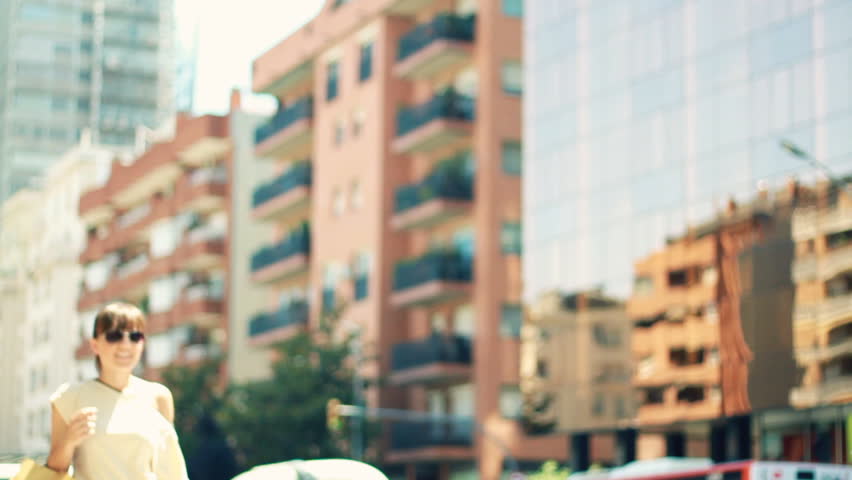 Happy young attractive woman walking with shopping bags in the city, slow motion