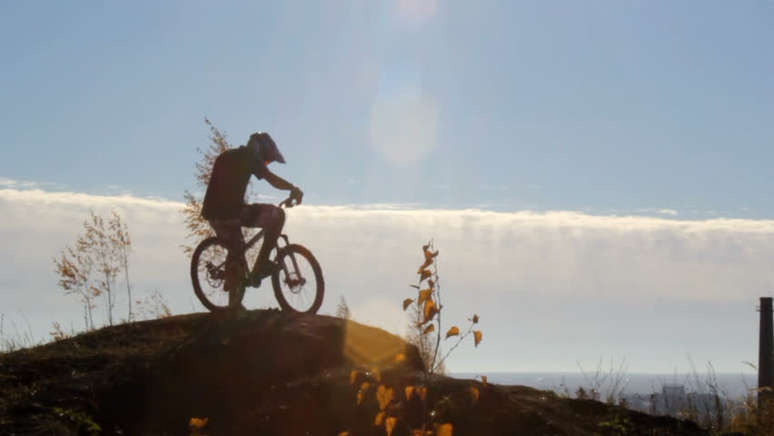 Rider on a bike in front of a cloudy sky 