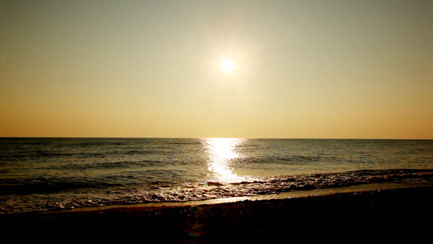 girl and boy go at beach holding hands for sea, silhouettes on sunset evening