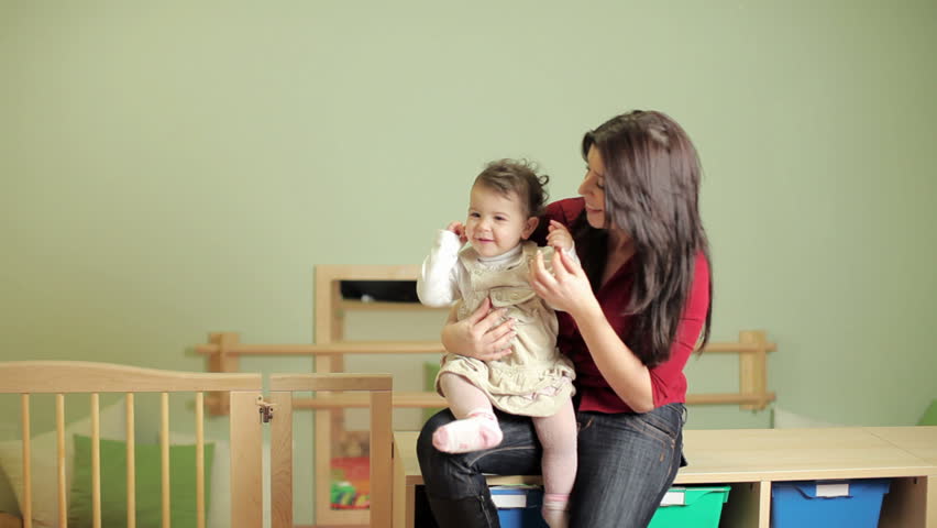 Young teacher with toddler in kindergarten