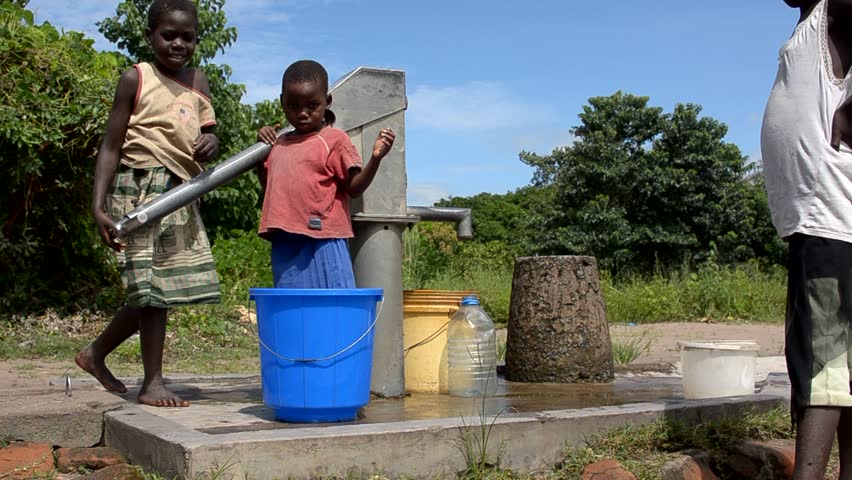 SALIMA, MALAWI - APRIL 10: Children pump drinking water from a well, April 10, 2011, Salima, Malawi. In rural Malawi, access to sanitation is considerably lower with only 15% - 30% of the rural population having access to a latrine. 
