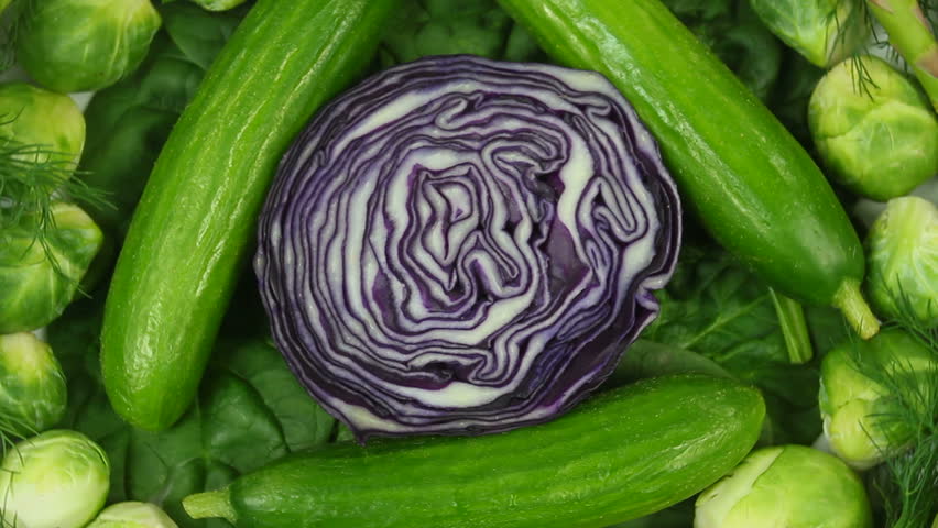 Beautiful arrangement of fresh, organic red cabbage, cucumbers and Brussels sprouts rotates. 1080p