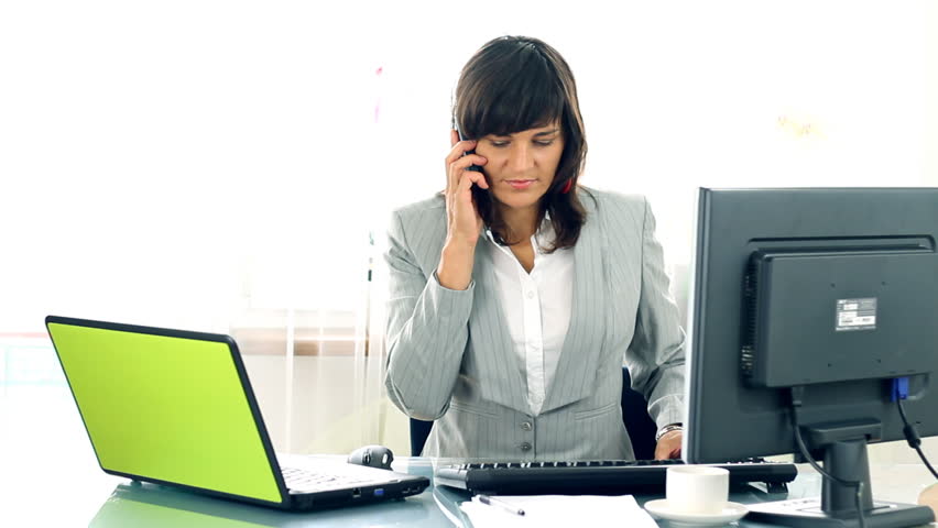 Busy multitasking attractive businesswoman in the office