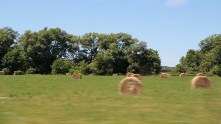Rural drive. Hayfield. Passing bales of hay in a field. Rural Ontario, Canada. 