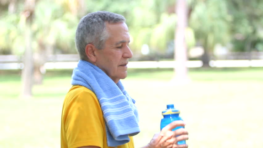 Senior fit healthy man 'toasting' the camera with a sports water bottle.