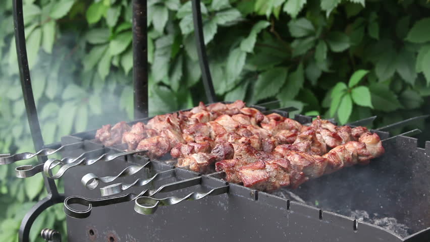 Man prepares pork shashlik on skewers 