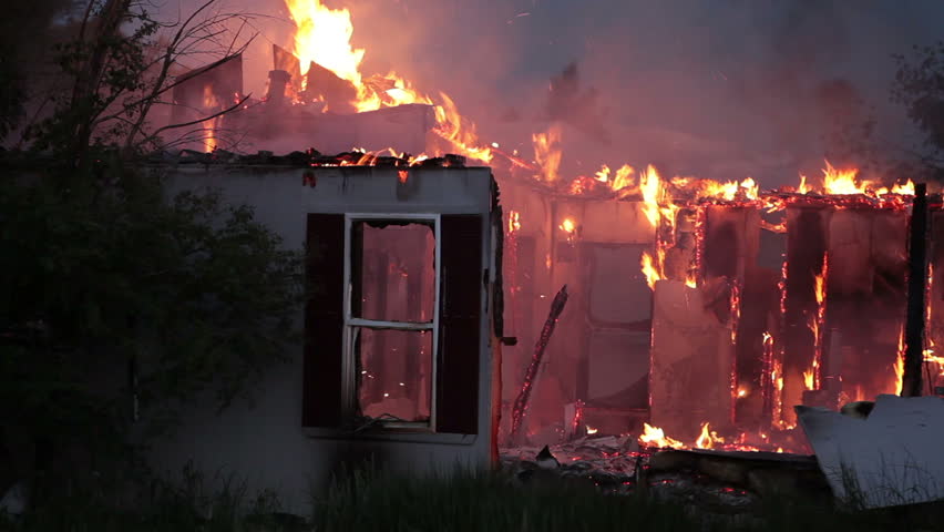 House fire with complete and total destruction during the night with flames burning the roof and walls.
