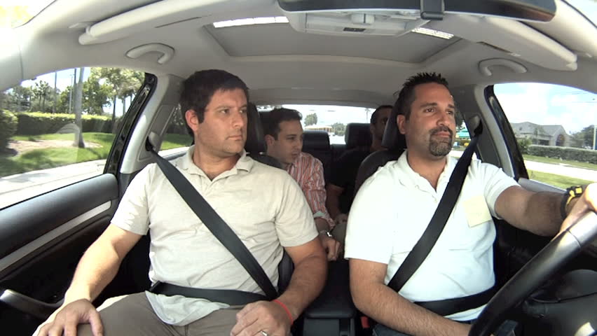 Four guys listening to music in the car