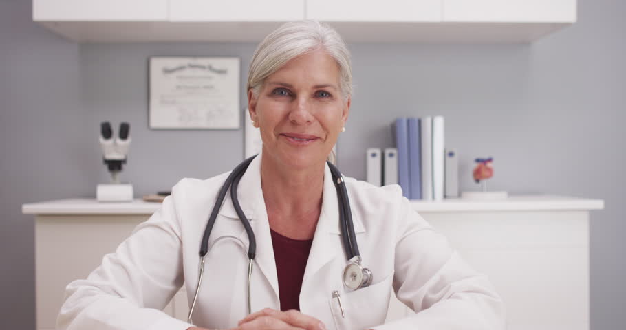 Beautiful Mature Medical Doctor Consulting With Patient POV Stock