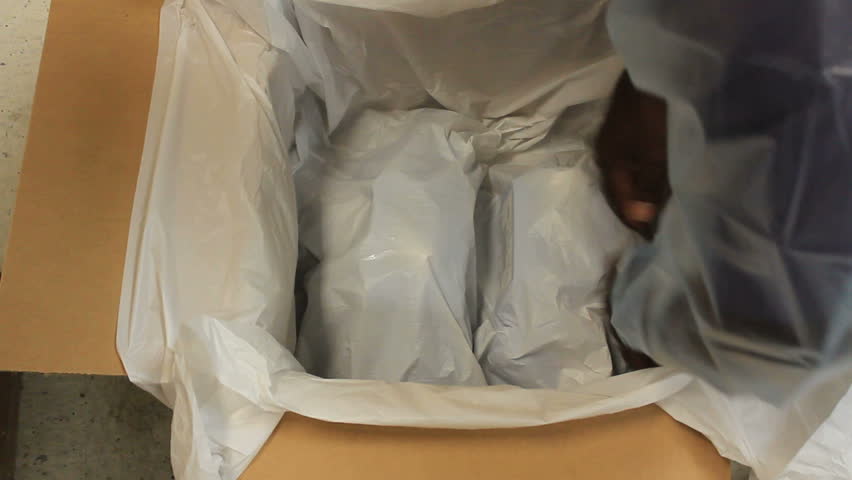 Man molds packing cloth around fragile items, sprays liquid that forms a foamy mousse that hardens into protective casing for safe shipping. 1080p