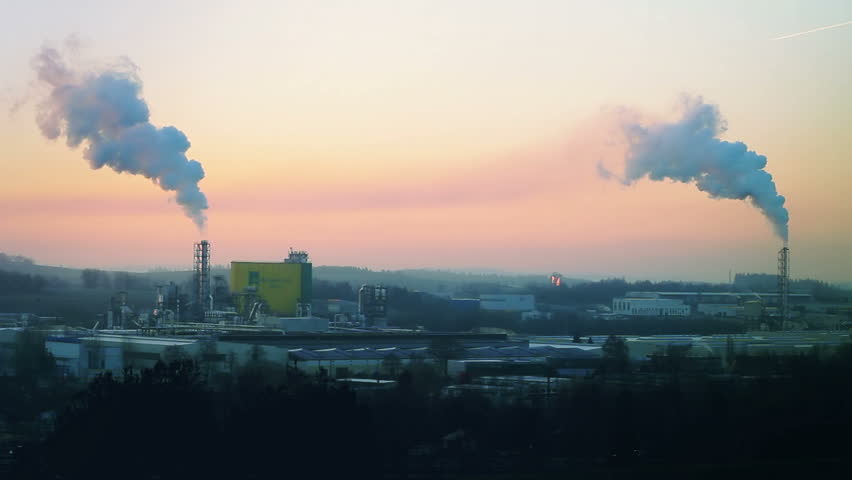 Sunrise silhouette of smoking factory