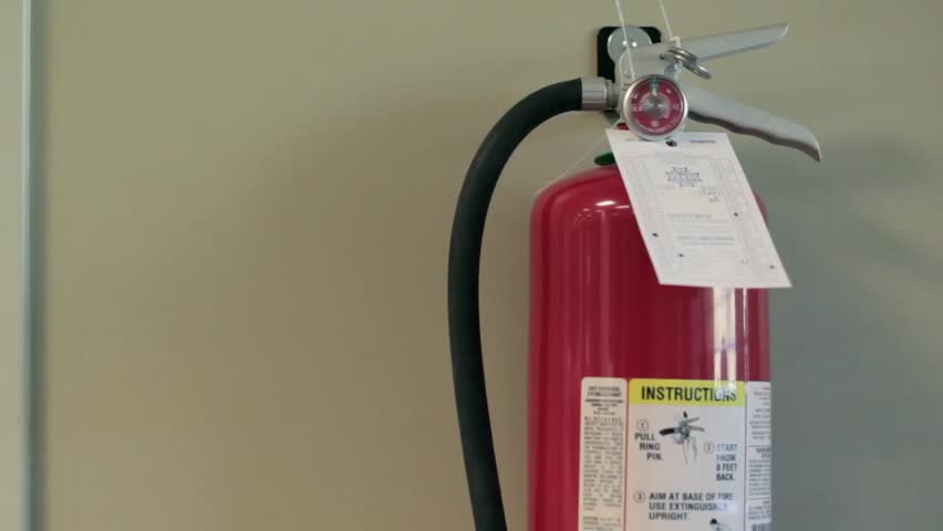 A man grabs a fire extinguisher.