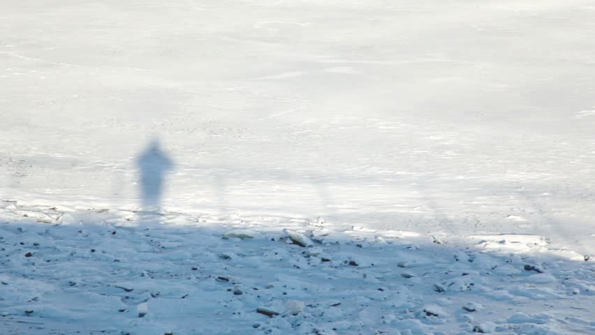 Moving shadow on snow man stand on deck, view from boat in motion