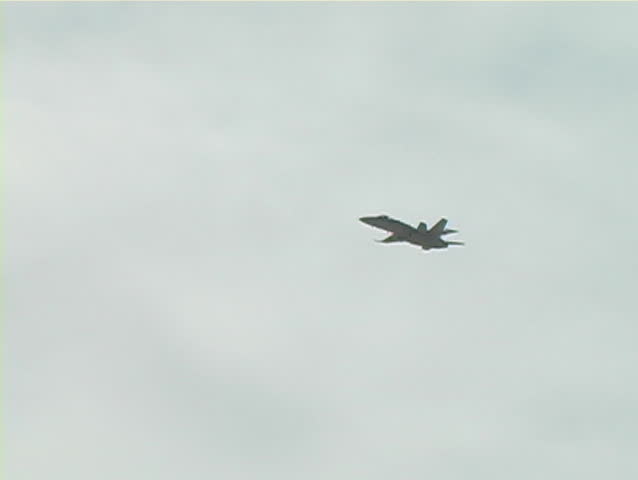 F-18 fighter jet pulls hard in a vertical climb.