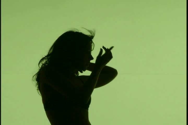 A woman's silhouette dancing against green background