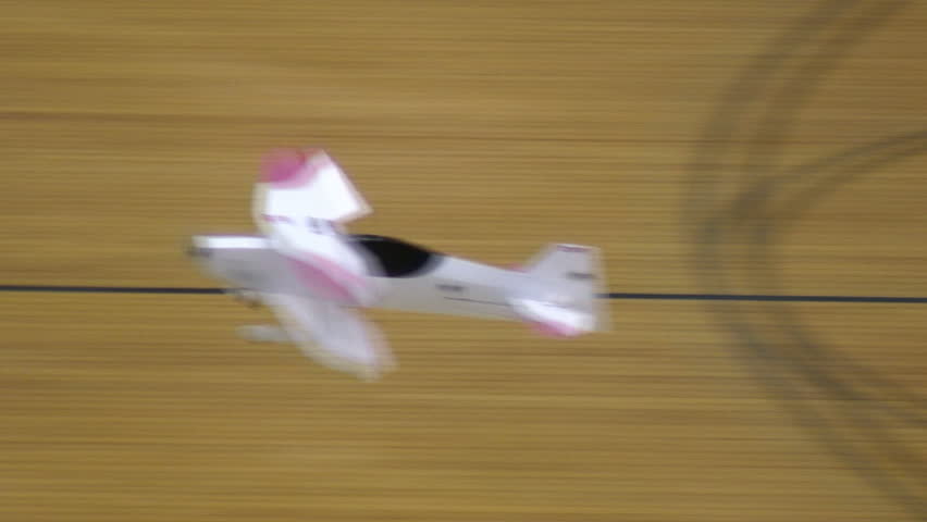 Radio-controlled foam model airplane performing aerobatic tricks at the competition venue