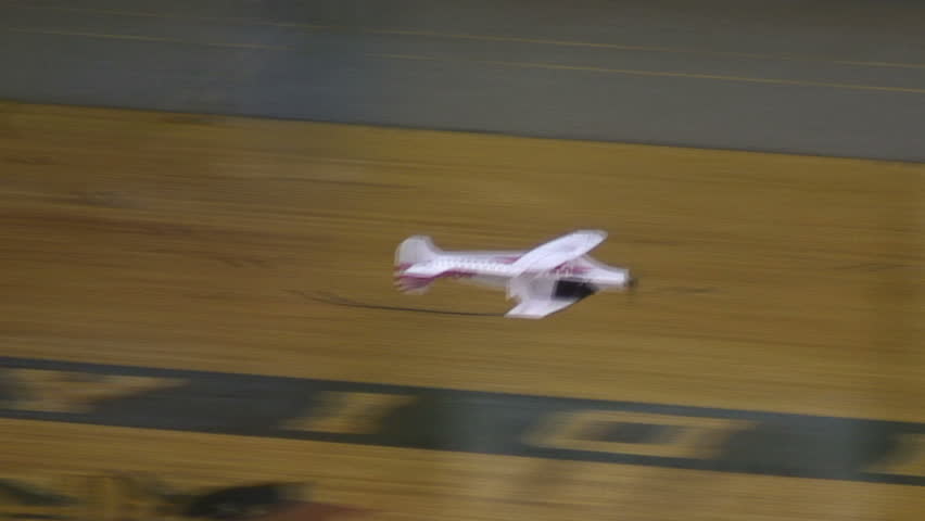 Radio-controlled foam model airplane performing aerobatic tricks at the competition venue