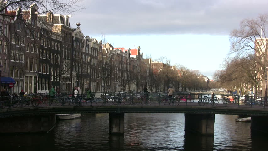 Pedestrians move across bridge in scenic Amsterdam