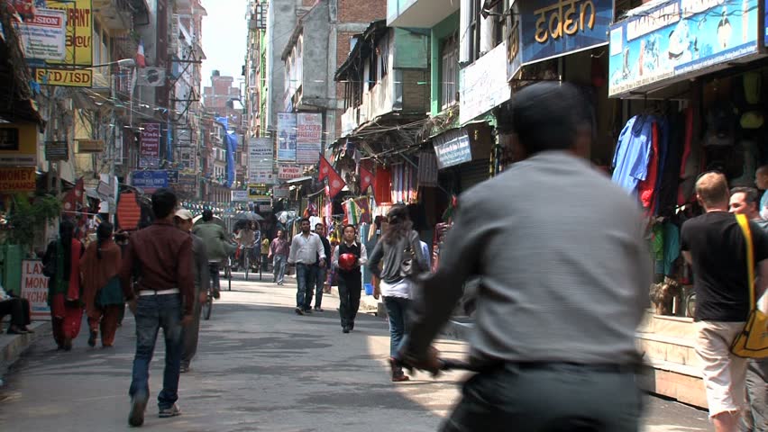 KATHMANDU - CIRCA 2010: People, cars and bikes circulate through the city circa 2010 in Kathmandu.