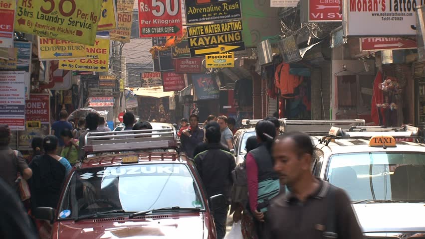KATHMANDU - CIRCA 2010: People, cars and bikes circulate through the city circa 2010 in Kathmandu.