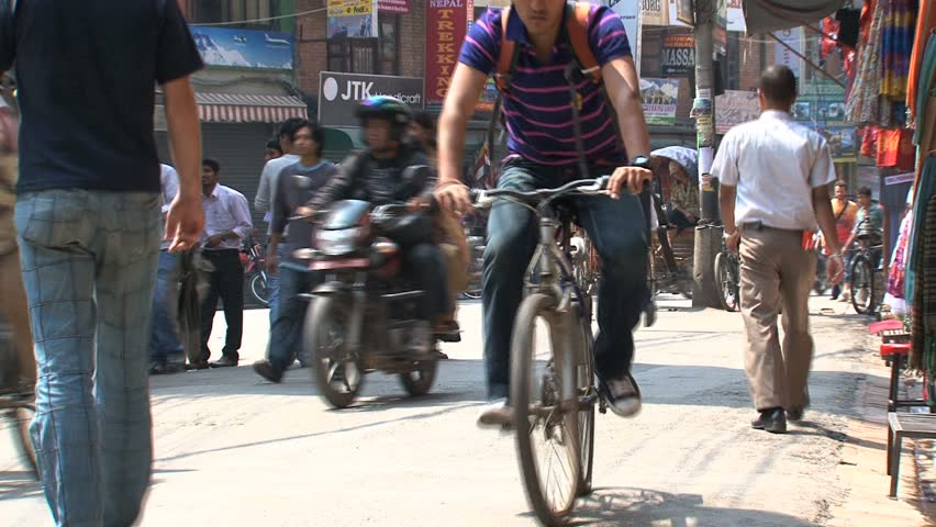 KATHMANDU - CIRCA 2010: People, cars and bikes circulate through the city circa 2010 in Kathmandu.