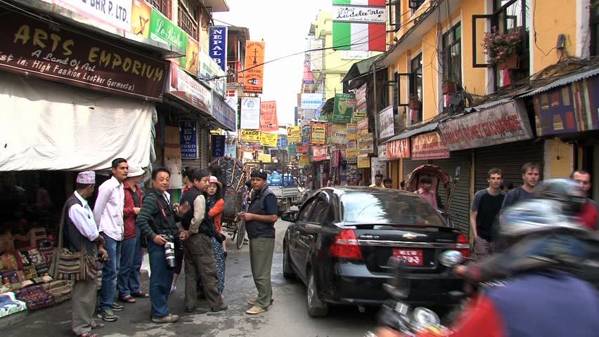KATHMANDU - CIRCA 2010: People, cars and bikes circulate through the city circa 2010 in Kathmandu.