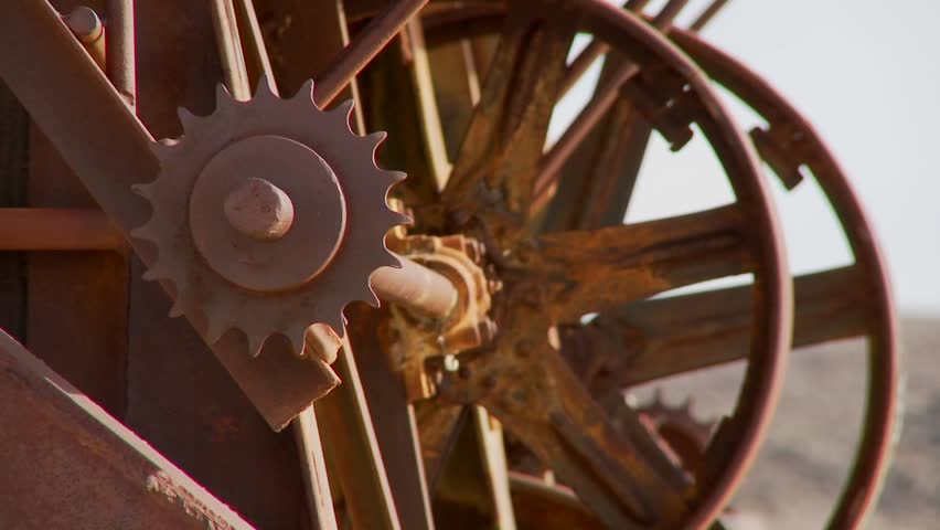 Old cogwheels rust in the sun at an abandoned mine.
