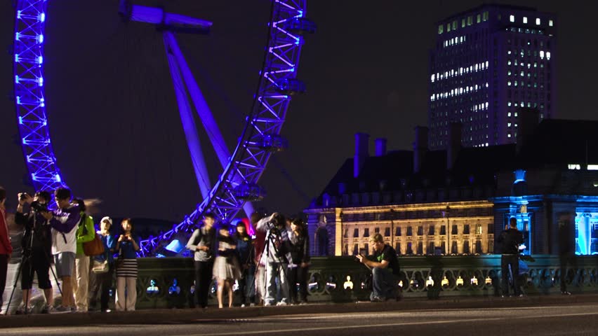 WESTMINSTER, LONDON - JULY 2011: (Timelapse View) London Eye at night from Westminster Bridge as traffic and people zip by circa July 2011 in London.