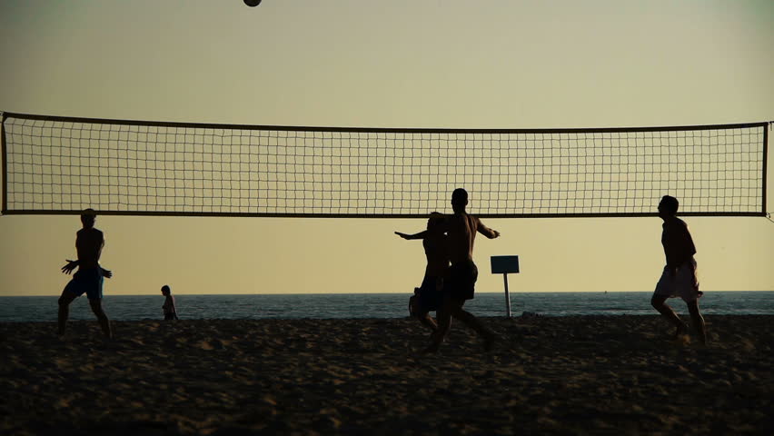 silhouette of volleyball players on the beach at sunset