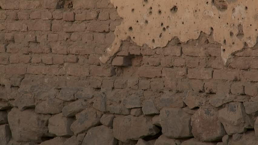 Tilt-up of bullet holes in a wall in Kabul, Afghanistan.